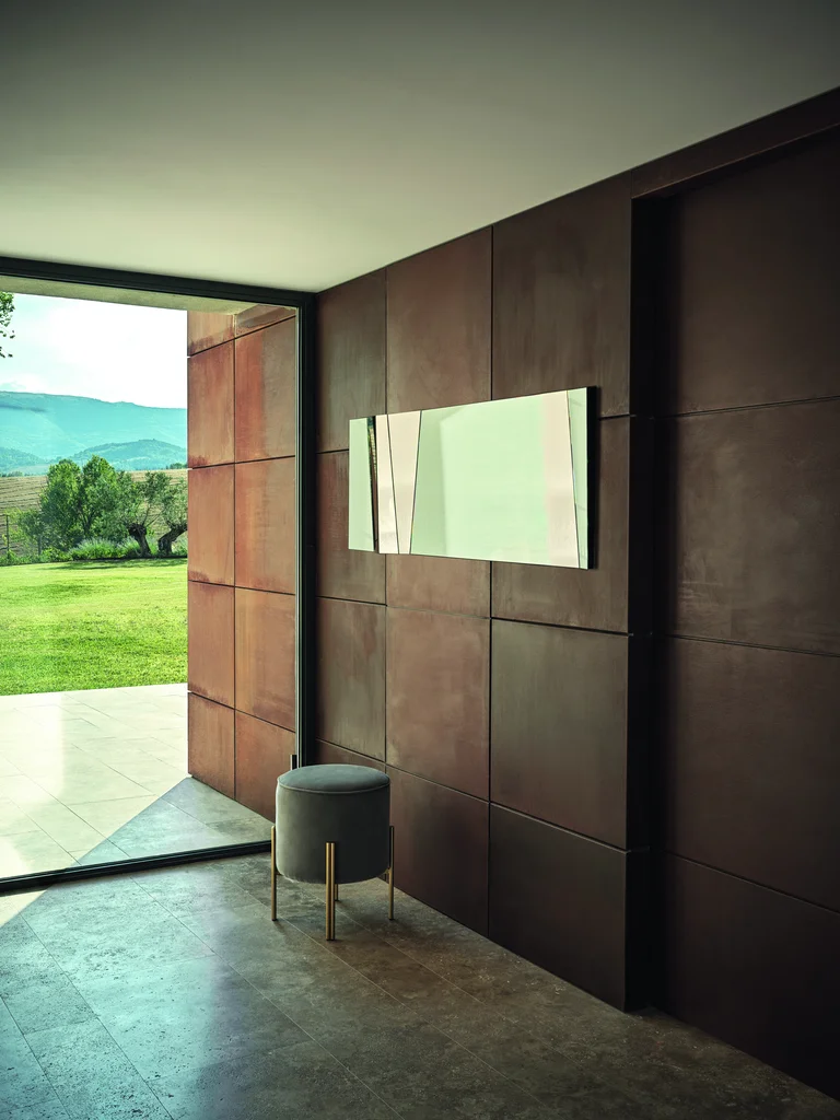 Ogledalo Illusion okačeno vodoravno u predsoblju sa tamnim zidnim panelima, pored tabureta